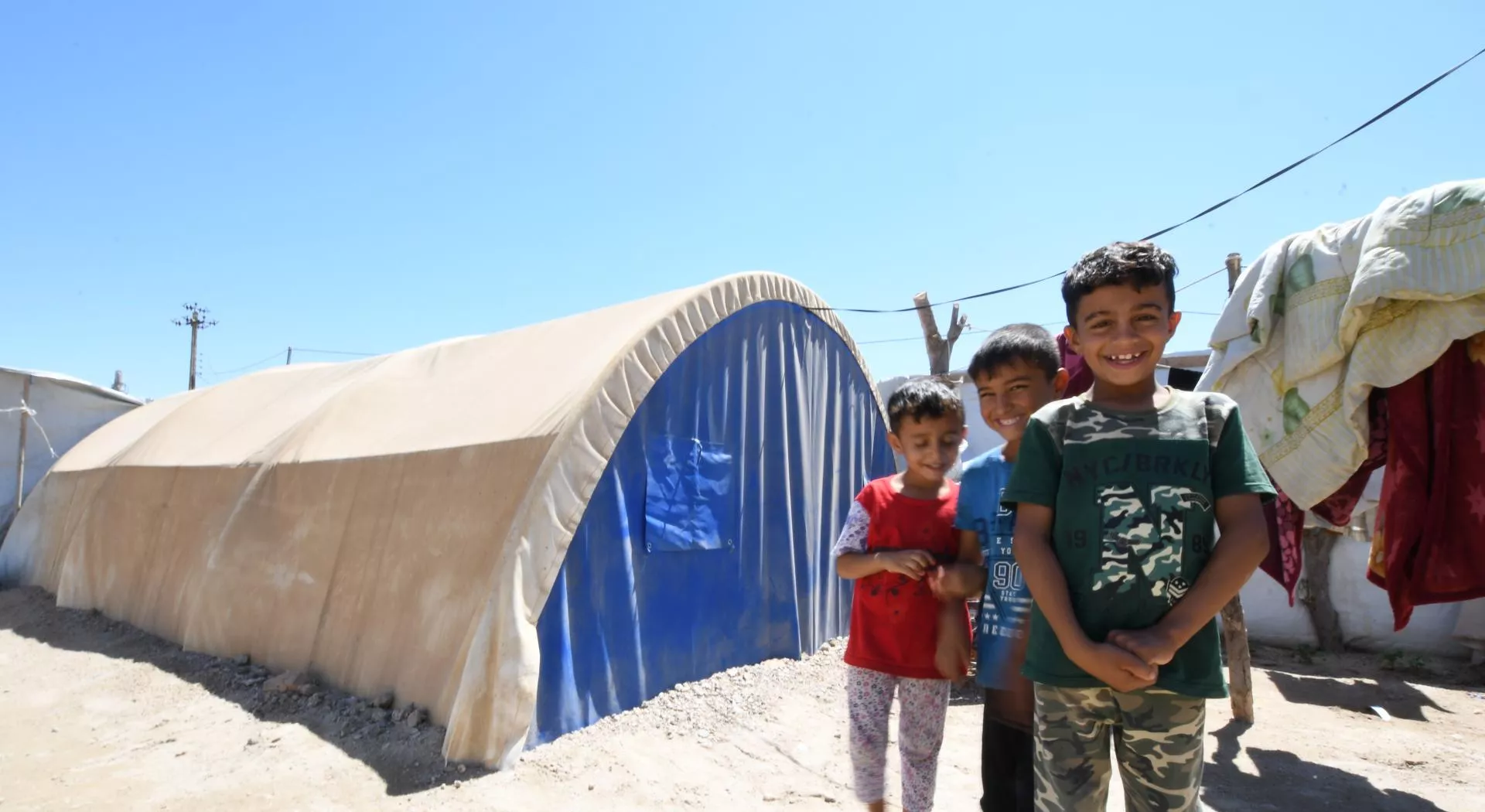 Kids in Iraq in front of their temporary shelter
