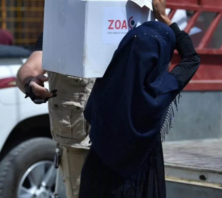 Frauenrechte in Afghanistan: Verhüllte Frau trägt ein Paket mit ZOA Aufschrift