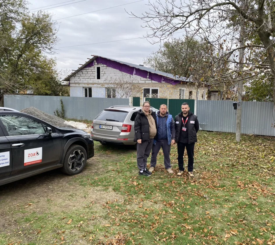 Anatolii and Olena in front of their rebuilt home