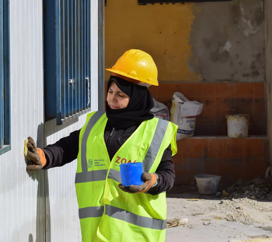 Woman at work to rehabilitate school in Syria