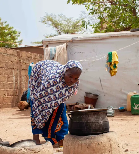 Vrouw kookt in mini-gasfornuisje