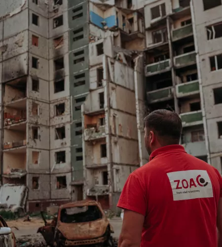 ZOA employee looking at broken buildings in Ukraine