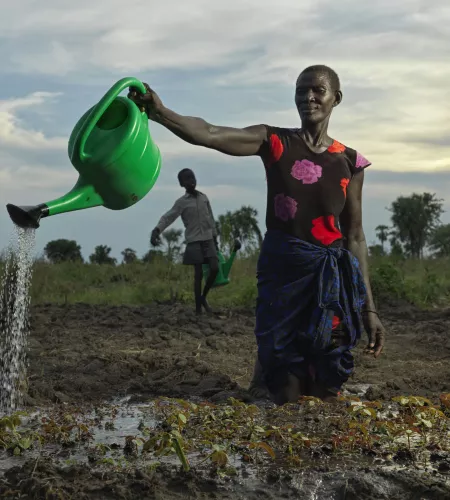 Vrouw bewatert land in Zuid-Sudan
