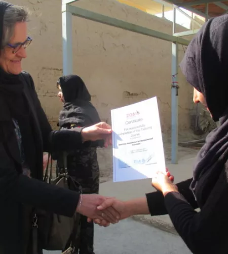 Rina Teeuwen hands out a certificate to one of the participants in a training