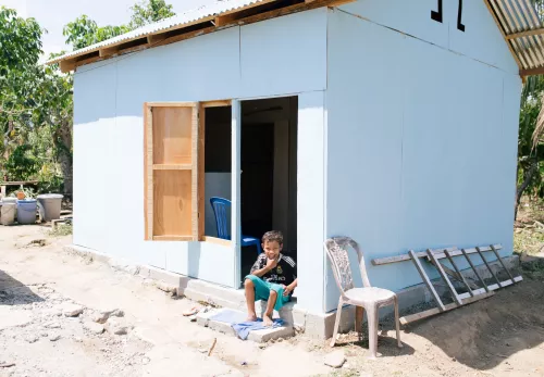 A boy in front of his house