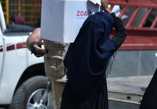 Verhüllte Frau trägt ein Nahrungsmittelpaket von ZOA