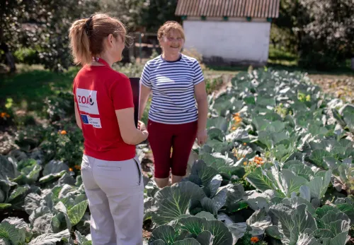 A ZOA employee standing in a field with a project participant
