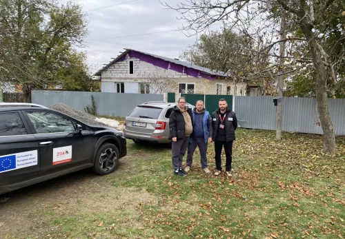 Anatolii and Olena in front of their rebuilt home