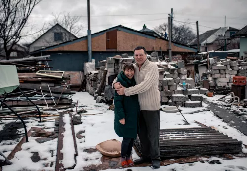 Beneficiaries standing in front of their rebuilt house