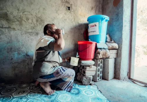 Man in Yemen drinks purified water